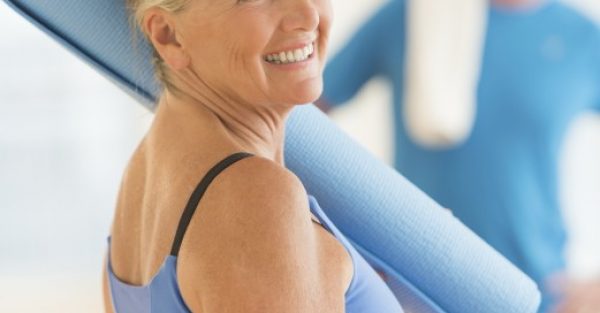 Senior Woman With Exercise Mat At Home